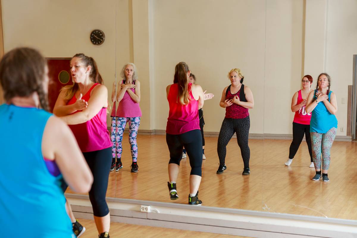 Flera personer genomför ett träningspass på ett gym.